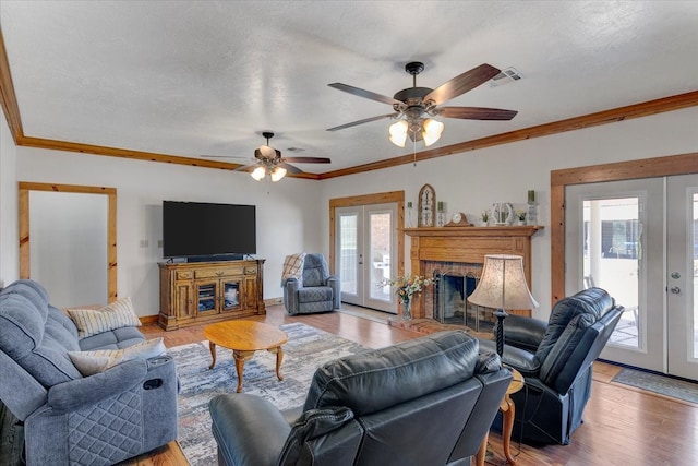 living room featuring plenty of natural light, french doors, ceiling fan, and hardwood / wood-style flooring