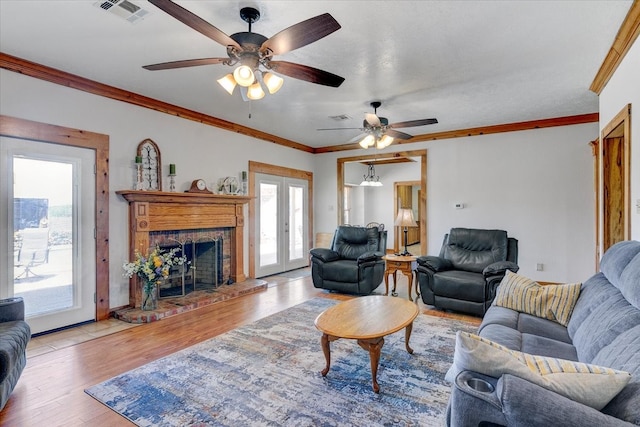 living room featuring ceiling fan, crown molding, hardwood / wood-style flooring, and a wealth of natural light