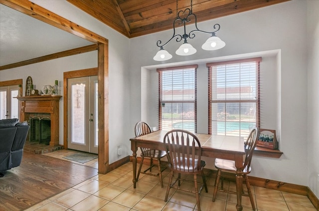 dining room with wood ceiling, vaulted ceiling, and light tile floors