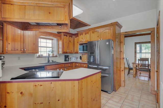 kitchen with stainless steel fridge with ice dispenser, sink, plenty of natural light, and light tile floors