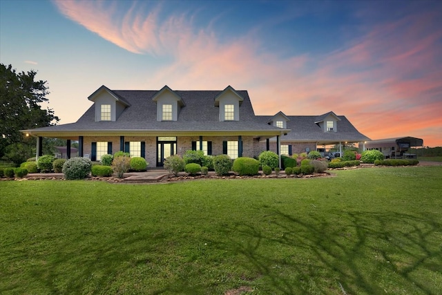 cape cod house featuring a lawn