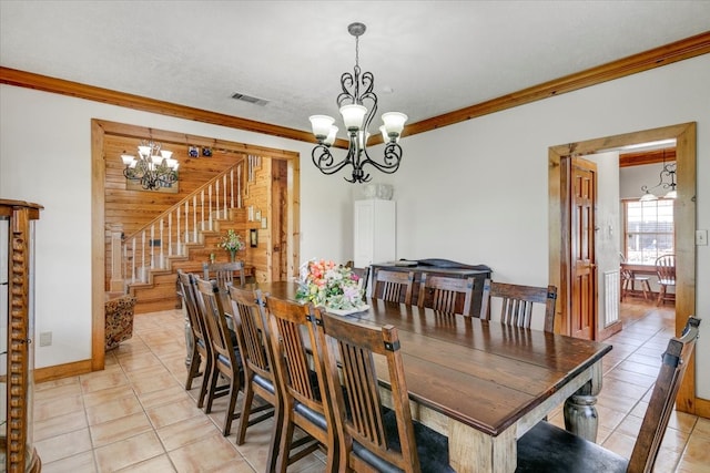 tiled dining area featuring ornamental molding and a notable chandelier