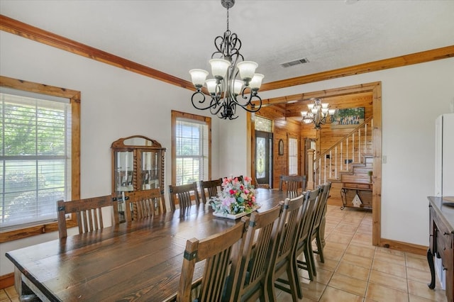 tiled dining room featuring crown molding and a notable chandelier