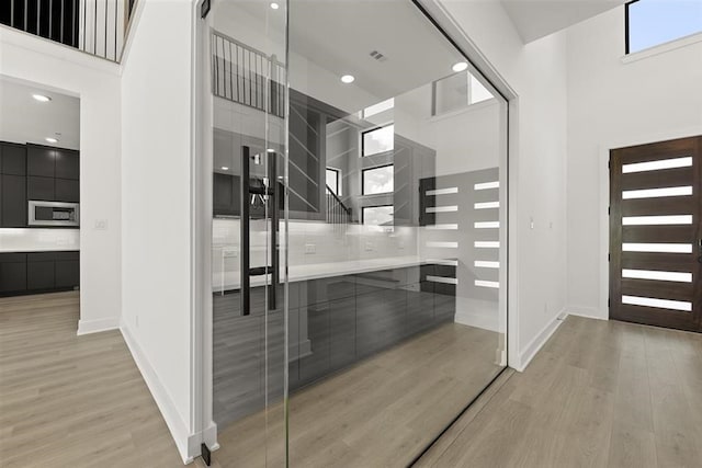 interior space featuring light hardwood / wood-style flooring and a towering ceiling