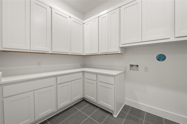 laundry area with washer hookup, dark tile patterned flooring, and cabinets