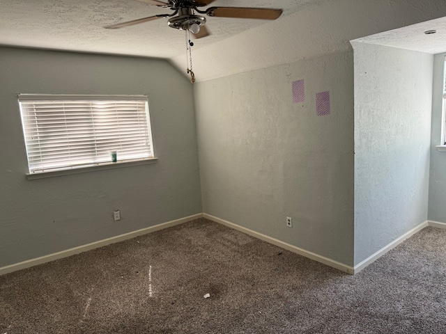 carpeted spare room with ceiling fan, a textured ceiling, and lofted ceiling