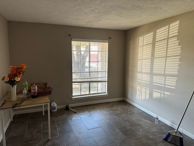 tiled empty room with a healthy amount of sunlight and a textured ceiling