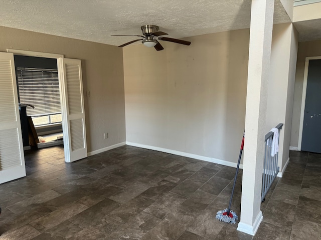 tiled empty room featuring ceiling fan and a textured ceiling