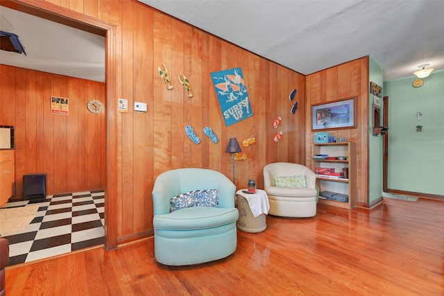 sitting room with wooden walls and light hardwood / wood-style floors