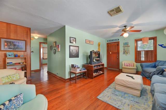 living room featuring wood-type flooring and ceiling fan