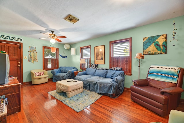 living room featuring dark wood-type flooring and ceiling fan