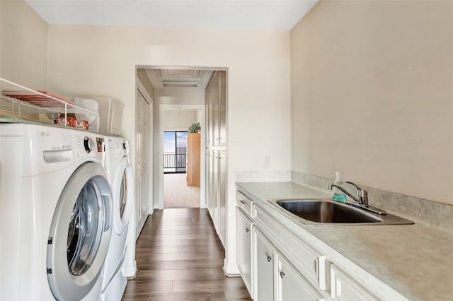 laundry room featuring sink, washer and dryer, and dark hardwood / wood-style floors