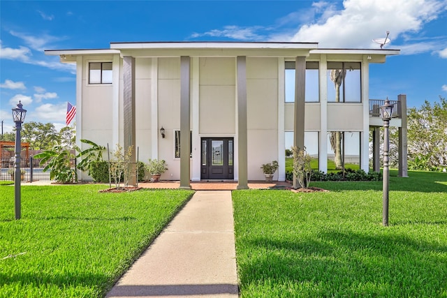 exterior space featuring stucco siding, fence, and a front yard