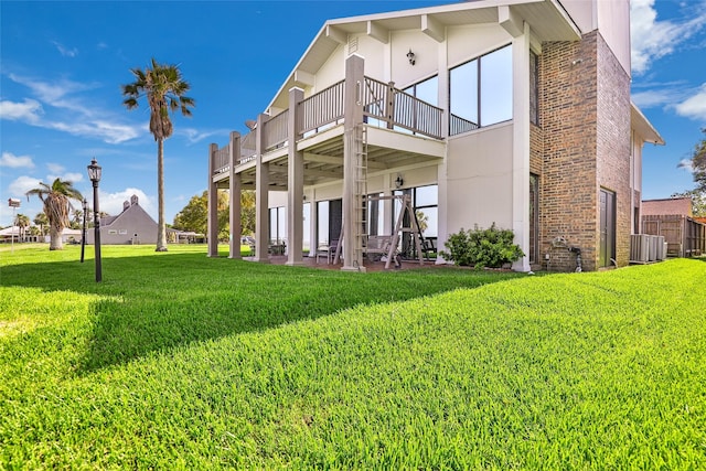 back of house featuring a patio area, a balcony, a yard, and central air condition unit