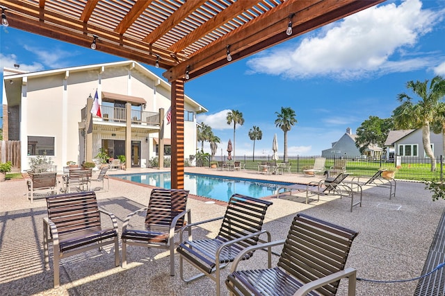 pool with fence, a pergola, and a patio