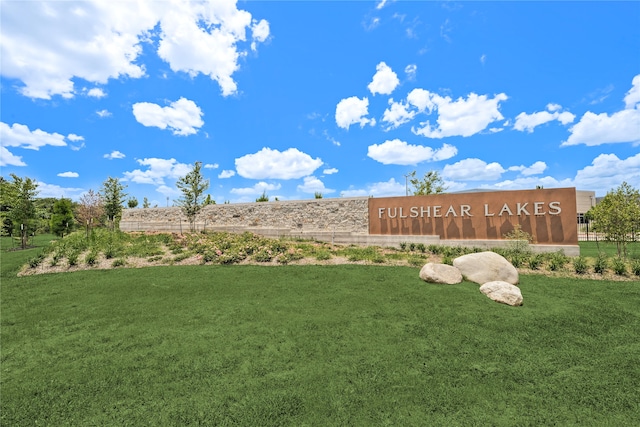 community / neighborhood sign with a lawn