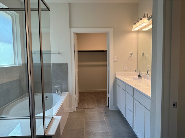 bathroom featuring tile patterned flooring, vanity, a healthy amount of sunlight, and separate shower and tub