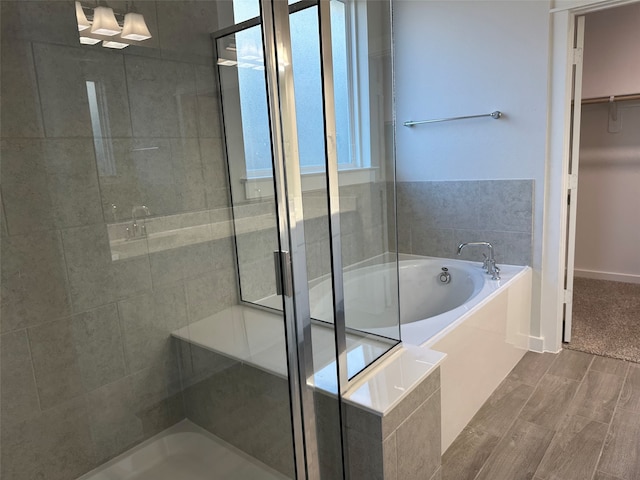 bathroom with hardwood / wood-style floors and independent shower and bath