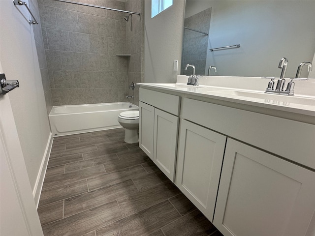 full bathroom featuring tiled shower / bath combo, vanity, and toilet