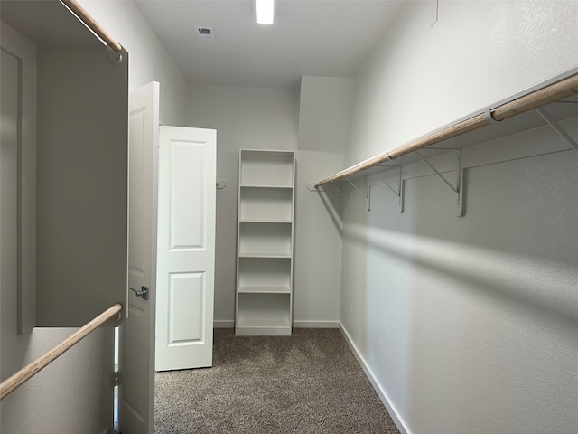 walk in closet featuring dark colored carpet