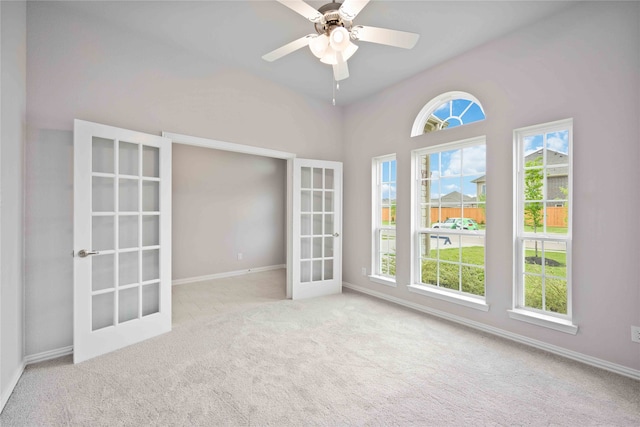 carpeted empty room with ceiling fan and french doors