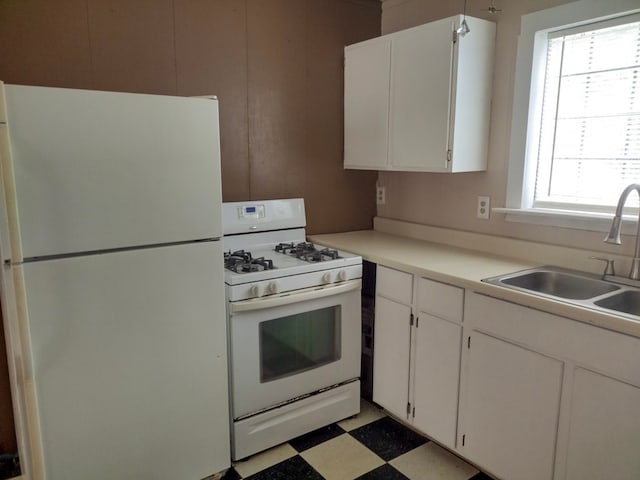 kitchen featuring light tile patterned floors, a healthy amount of sunlight, white cabinets, and white appliances