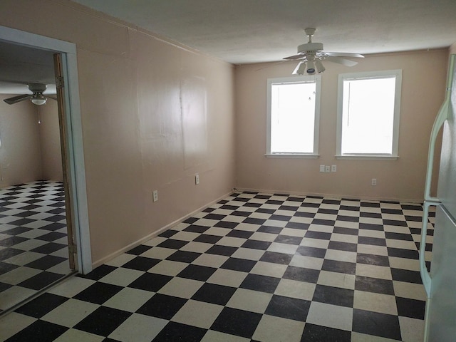 spare room featuring dark tile patterned floors and ceiling fan