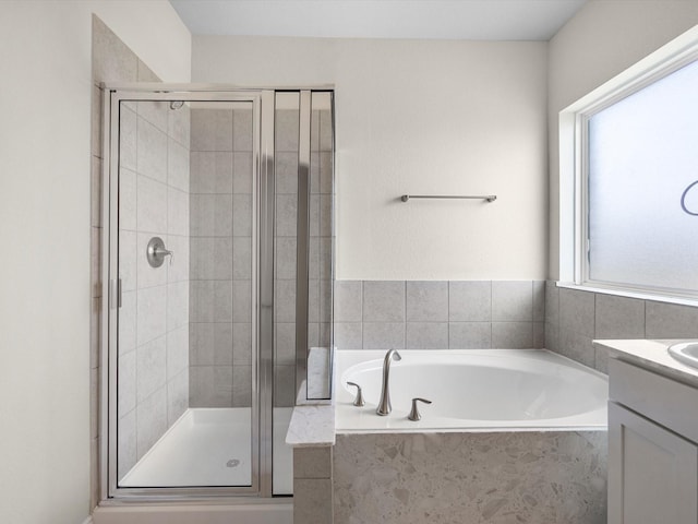 full bath with a garden tub, a shower stall, and vanity