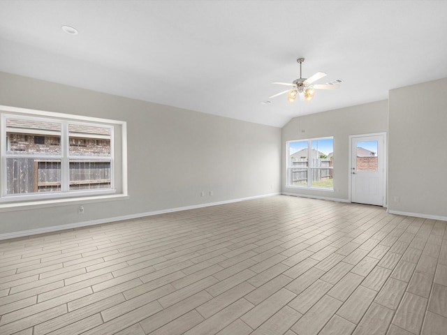 spare room featuring ceiling fan, visible vents, baseboards, vaulted ceiling, and light wood finished floors