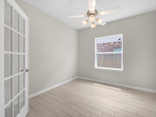 empty room featuring baseboards, ceiling fan, and light wood finished floors