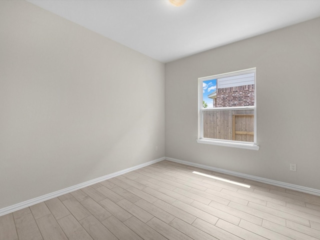 unfurnished room with baseboards and wood finished floors