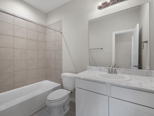 full bathroom with tiled shower / bath, vanity, toilet, and tile patterned floors