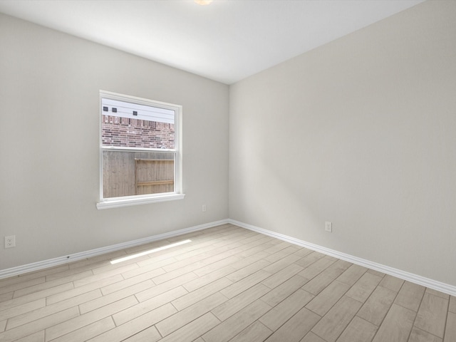 unfurnished room with light wood-style flooring and baseboards