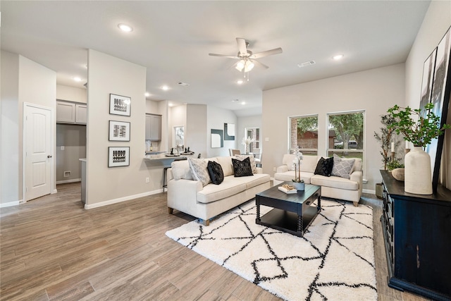 living room with ceiling fan and light hardwood / wood-style floors