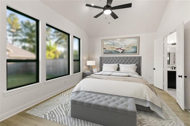 bedroom with ensuite bath, ceiling fan, light hardwood / wood-style floors, and lofted ceiling