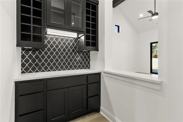 kitchen featuring backsplash, vaulted ceiling, and ceiling fan