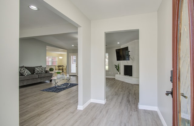 foyer entrance featuring a fireplace and light hardwood / wood-style flooring