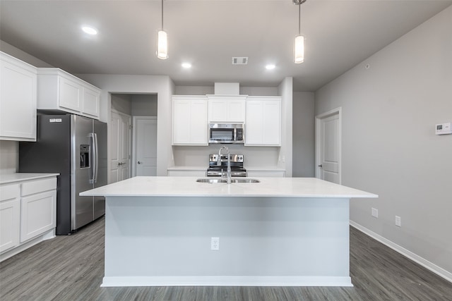 kitchen with appliances with stainless steel finishes, hardwood / wood-style floors, a center island with sink, and white cabinets