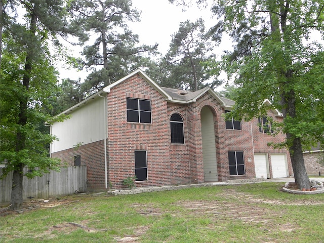 view of front of home featuring a garage, a front yard, fence, and brick siding