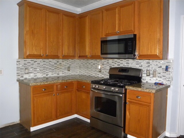 kitchen with dark wood-style floors, appliances with stainless steel finishes, light stone counters, and brown cabinets