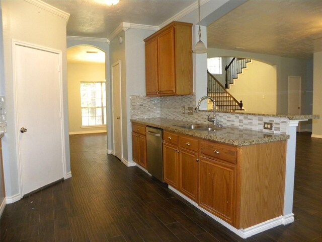 kitchen featuring arched walkways, pendant lighting, stainless steel dishwasher, a sink, and light stone countertops