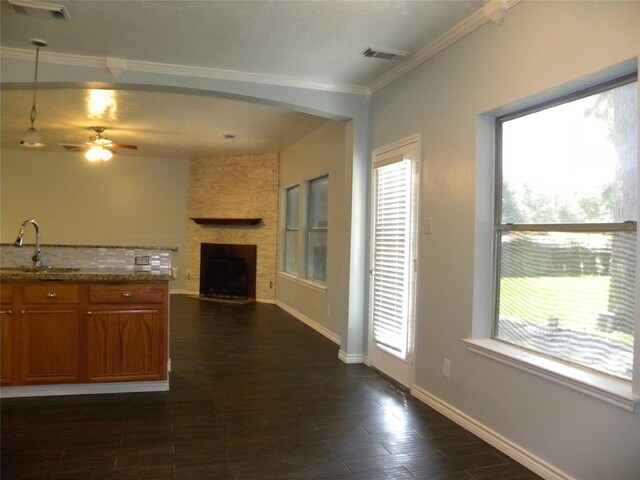 kitchen featuring open floor plan, a sink, visible vents, and brown cabinets