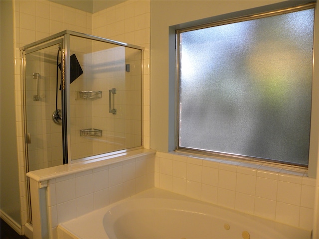 bathroom featuring plenty of natural light and shower with separate bathtub