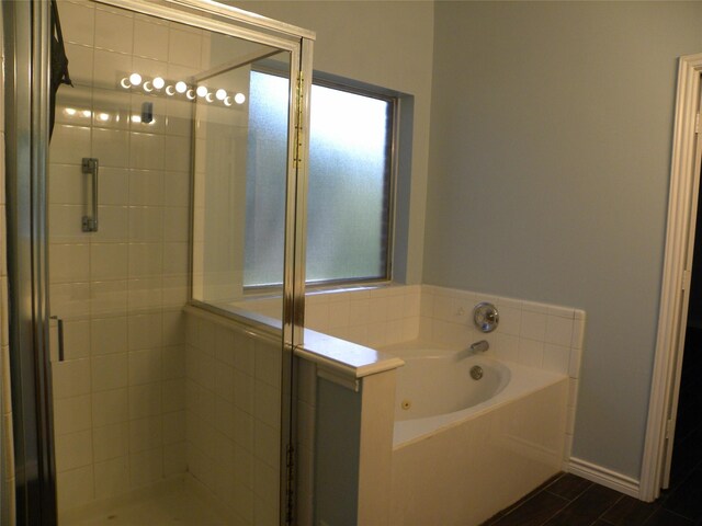 full bath featuring a shower stall, baseboards, and a bath