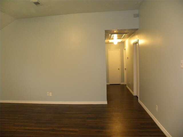 hall featuring dark hardwood / wood-style flooring and vaulted ceiling