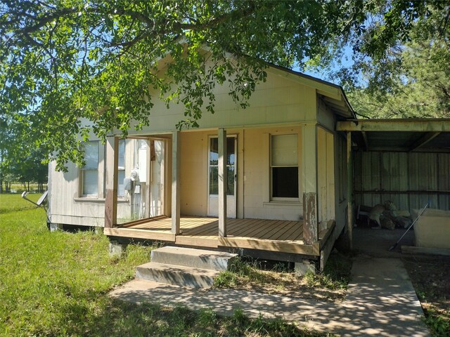 rear view of house with a wooden deck and a lawn