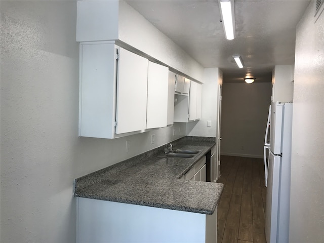 kitchen with white fridge, dark hardwood / wood-style floors, sink, and white cabinetry