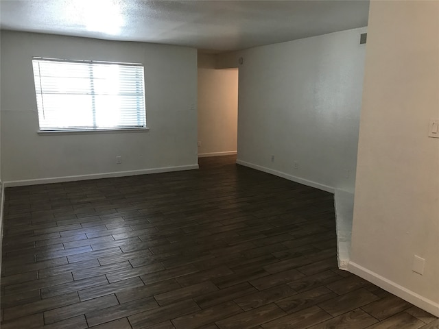 empty room with dark wood-type flooring