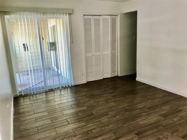 unfurnished bedroom featuring a closet and dark hardwood / wood-style floors