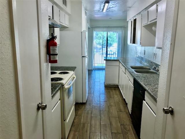 kitchen featuring dark stone countertops, sink, white range with electric cooktop, and white cabinetry